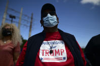 Supporters of president Donald Trump gather moments before leaving for the headquarters of the Republican party in support of his candidacy a few weeks before the presidential election next November, in Carolina, Puerto Rico, Sunday, Oct. 18, 2020. President Donald Trump and former Vice President Joe Biden are targeting Puerto Rico in a way never seen before to gather the attention of tens of thousands of potential voters in the battleground state of Florida. (AP Photo/Carlos Giusti)