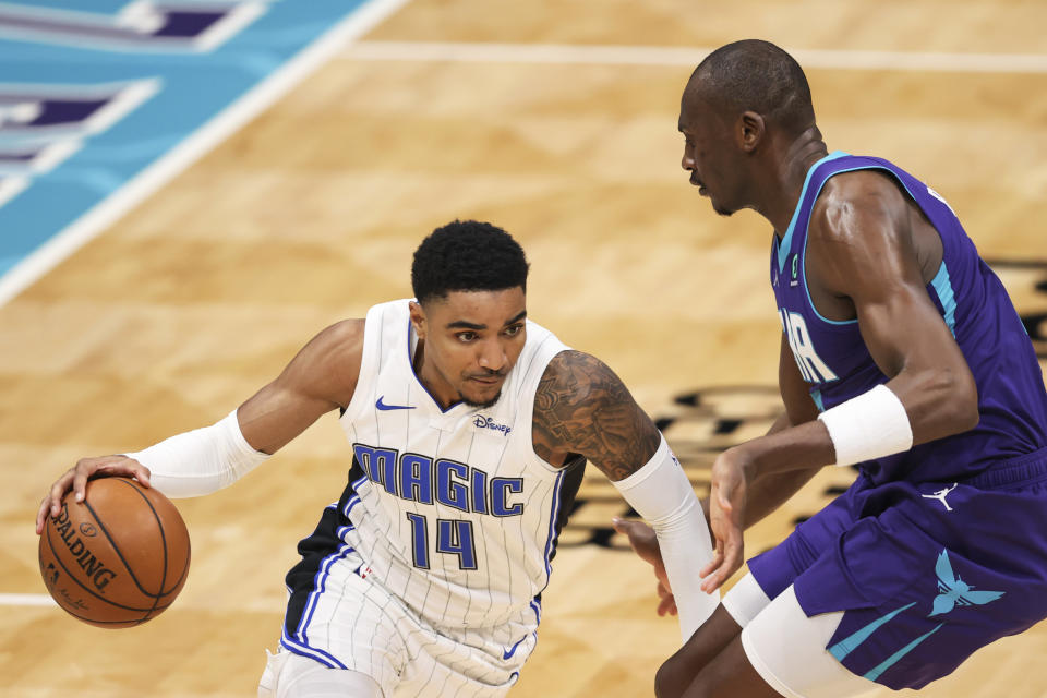 Orlando Magic guard Gary Harris (14) drives on Charlotte Hornets center Bismack Biyombo during the second half of an NBA basketball game in Charlotte, N.C., Friday, May 7, 2021. (AP Photo/Nell Redmond)