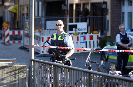 Police stands guard in a street near a place where a man drove a van into a group of people sitting outside a popular restaurant in the old city centre of Muenster, Germany, April 7, 2018. REUTERS/Leon Kuegeler