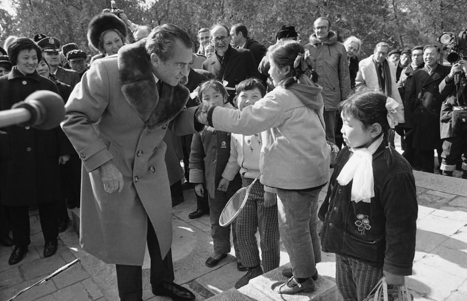 FILE - Then First lady Pat Nixon watches behind him, then U.S. President Richard Nixon shakes hands with a Chinese girl in Beijing on Feb. 24, 1972 during his tour of historic sites of the Chinese capital. At the height of the Cold War, U.S. President Richard Nixon flew into communist China's center of power for a visit that over time would transform U.S.-China relations and China's position in the world in ways that were unimaginable at the time. (AP Photo, File)