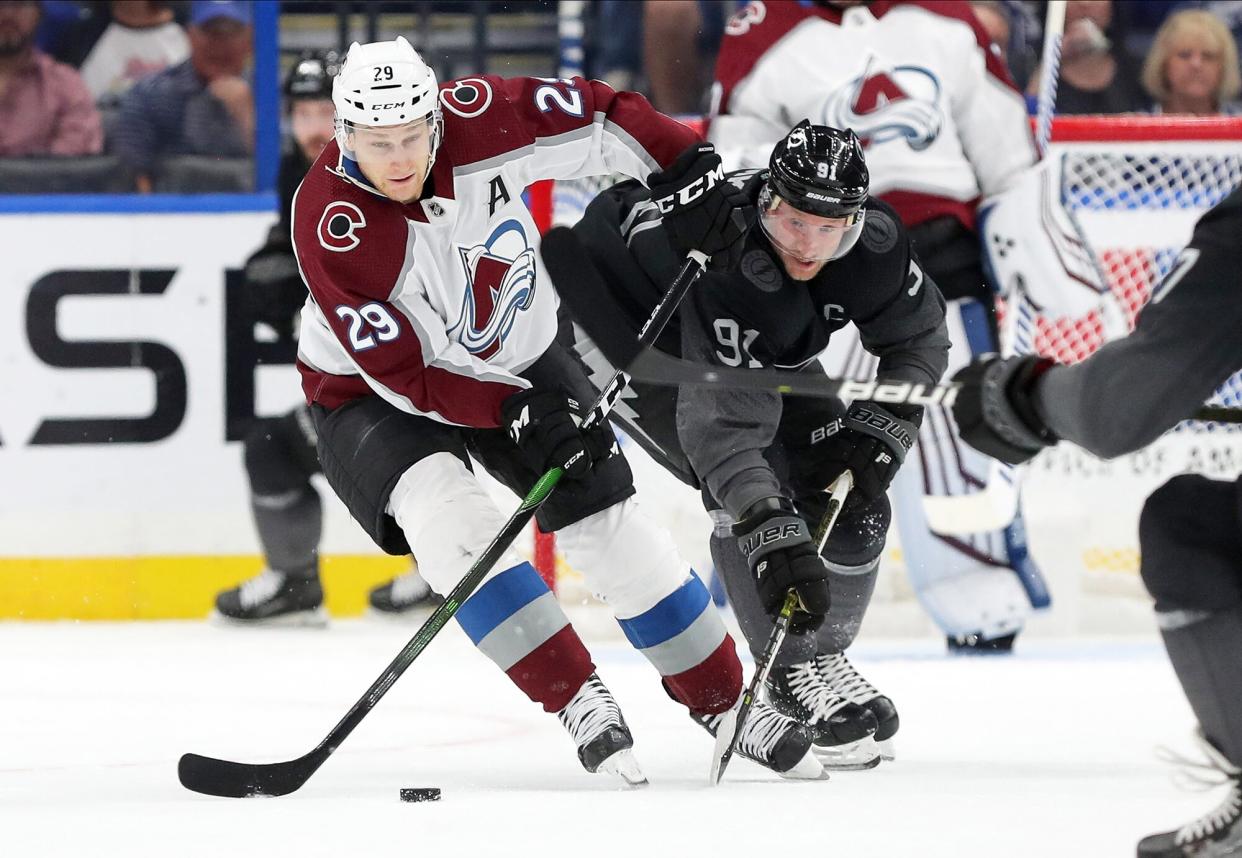 Nathan MacKinnon #29 of the Colorado Avalanche avoids a check from Steven Stamkos #91 of the Tampa Bay Lightning