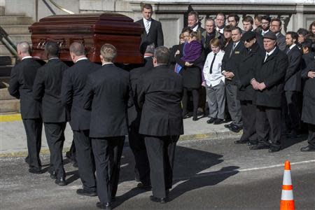 Mimi O'Donell (C), former partner of actor Phillip Seymour Hoffman, holds her daughter Willa as the casket arrives for the funeral of actor Phillip Seymour Hoffman in the Manhattan borough of New York, February 7, 2014. REUTERS/Brendan McDermid