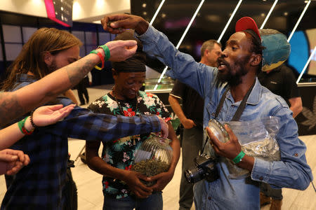 Cannabis activist Steven Thapelo Khundu hands out cannabis buds from a plastic bag at the expo entrance, encouraging attendees to bring them inside, during the opening of the four-day expo in Pretoria, South Africa, December 13, 2018. REUTERS Siphiwe Sibeko