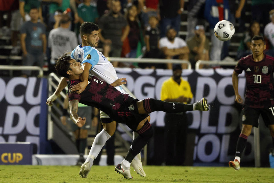 Mexico defender Carlos Salcedo (3) and Guatemala forward Darwin Lom (14) battle for the ball during the first half of a CONCACAF Gold Cup Group A soccer match in Dallas, Wednesday, July 14, 2021. (AP Photo/Michael Ainsworth)