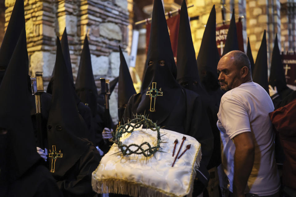 A member of the Nazarene brotherhood carries a crown of thorns on a decorative pillow during a Holy Week procession, in Zipaquira, Colombia, Friday, March 29, 2024. Holy Week commemorates the last week of Jesus' earthly life which culminates with his crucifixion on Good Friday and his resurrection on Easter Sunday. (AP Photo/Ivan Valencia)