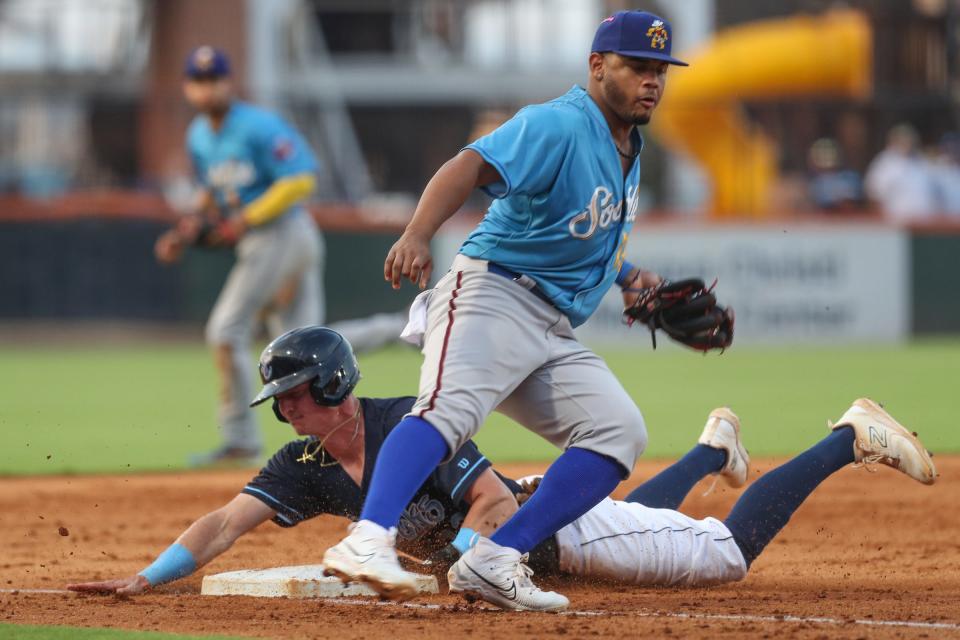 Sod Poodles third baseman Deyvison De Los Santos attempts to tag Hooks' Zach Dezenzo out during a homestand against the Sod Poodles at Whataburger Field on Thursday, June 22, 2023.