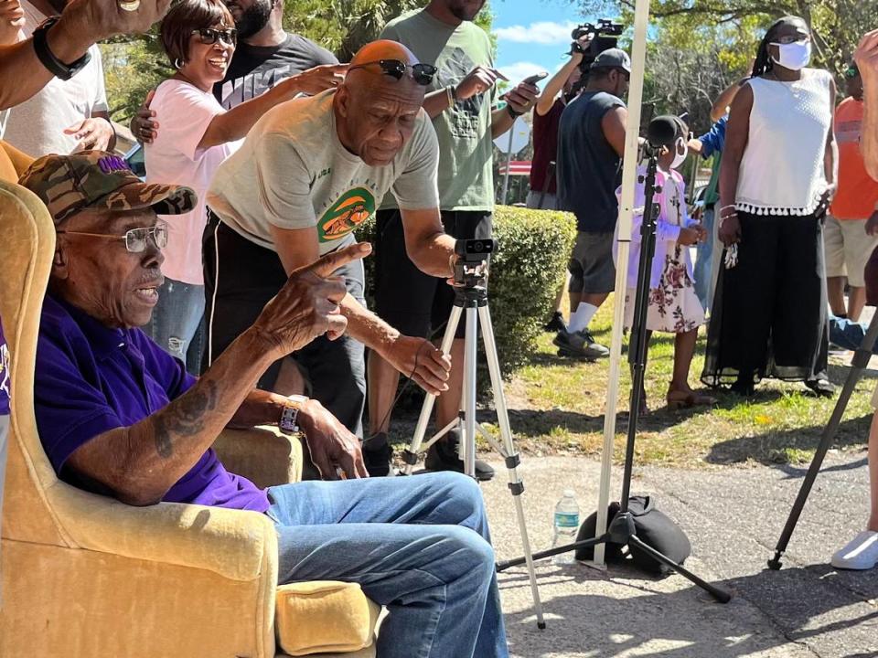 Coach Eddie Shannon points at guest as they drive-by to wish him a happy 100th birthday in Palmetto in 2022.