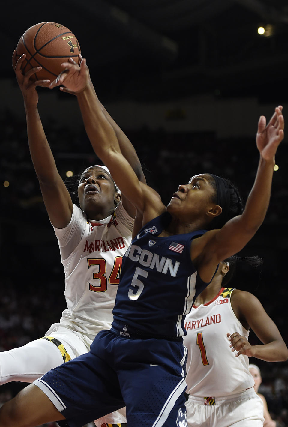 Maryland's Brianna Fraser, left, and Connecticut's Crystal Dangerfield vie for a rebound during the first half of an NCAA college basketball game, Thursday, Dec. 29, 2016 in College Park, Md. Connecticut won 87-81. (AP Photo/Gail Burton)