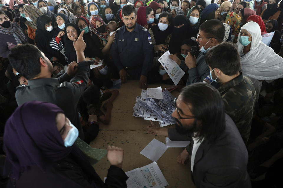 Afghans wait to submit documents inside the passport office in Kabul, Afghanistan