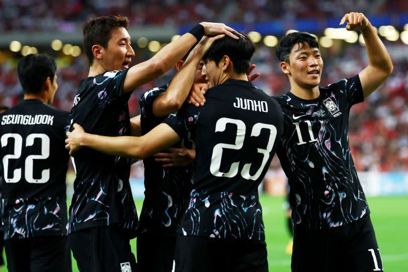 Stoke City playmaker Bae Junho is mobbed by teammates after scoring on his senior debut for South Korea in a thrashing of Singapore.