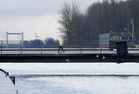 A worker walks across a Humbeek lift bridge, which was damaged when lowered onto a barge, blocking Brussels-Scheldt canal traffic, in Humbeek near Brussels, Belgium, January 17, 2019. REUTERS/Francois Lenoir