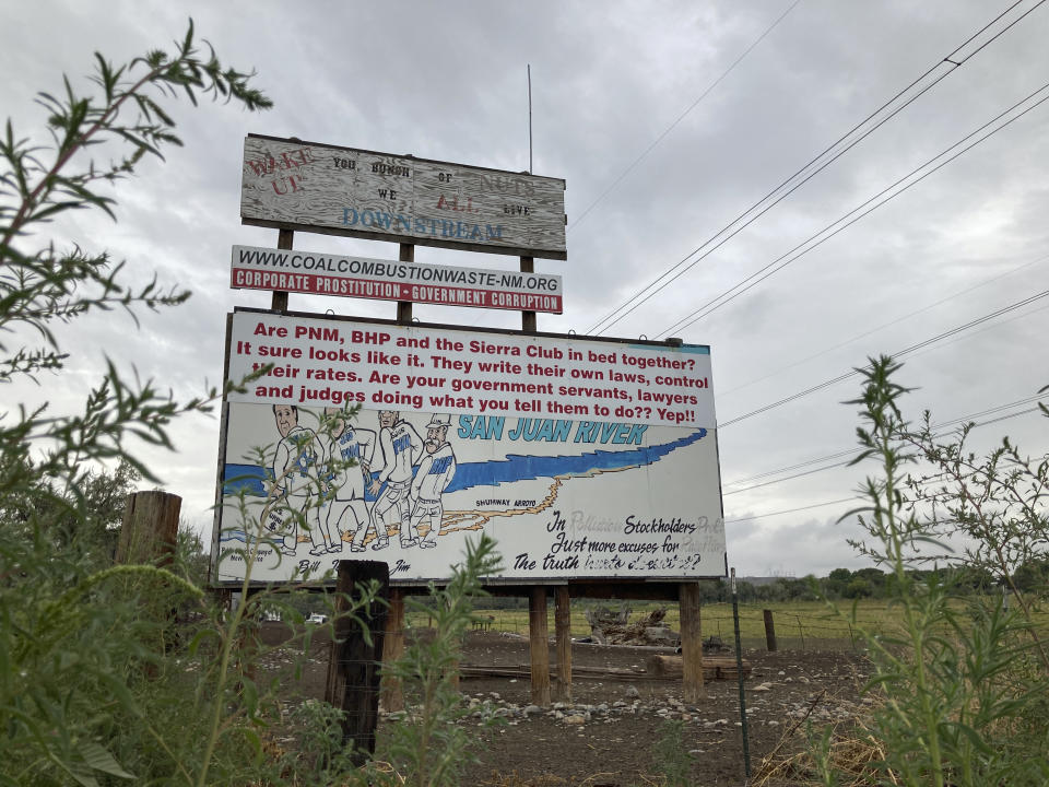 A weathered billboard that has been used to protest the coal-fired San Juan Generating Station near Waterflow, N.M., is seen Sept. 21, 2022. Environmentalists had fought for years to force the closure of the plant, saying millions of dollars in pollution control systems installed over the last two decades were not enough. (AP Photo/Susan Montoya Bryan)