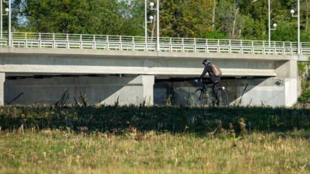 A cyclist in a mask pedals along the Ottawa River in Ottawa this week. (Francis Ferland/CBC - image credit)