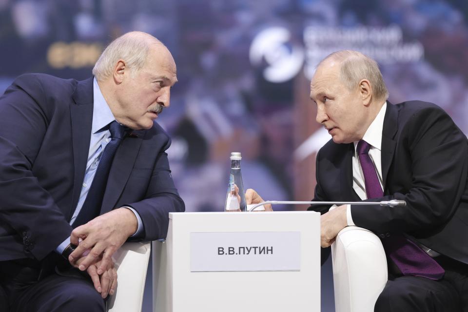 In this photo released by Roscongress Foundation, Russian President Vladimir Putin, right, and Belarusian President Alexander Lukashenko talk to each other during the plenary session of the Eurasian Economic Forum in Moscow, Russia, Wednesday, May 24, 2023. (Vyacheslav Viktorov, Roscongress Foundation via AP)