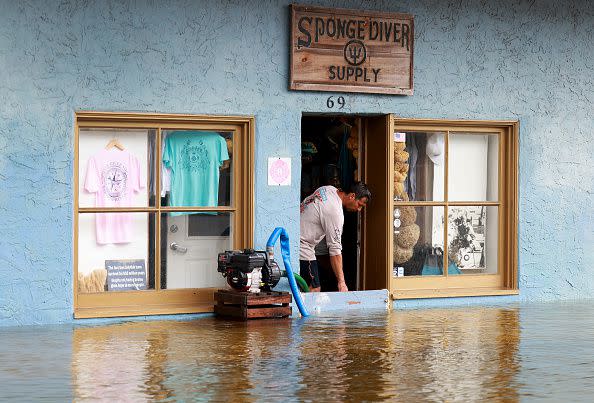 TARPON SPRINGS, FLORIDA - AUGUST 30: A store owner (who did not want to give his name) uses a sump pump to try to keep water out of his store after Hurricane Idalia passed offshore on August 30, 2023 in Tarpon Springs, Florida. Hurricane Idalia hit the Big Bend area on the Gulf Coast of Florida as a Category 3 storm. (Photo by Joe Raedle/Getty Images)