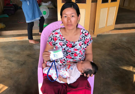 The wife of Lamung Brang Aung, a miner whose body cannot be retrieved from the collapsed mud pond, poses for a photo with their child in Hpakant, Kachin, Myanmar April 28, 2019. REUTERS/Shoon Naing