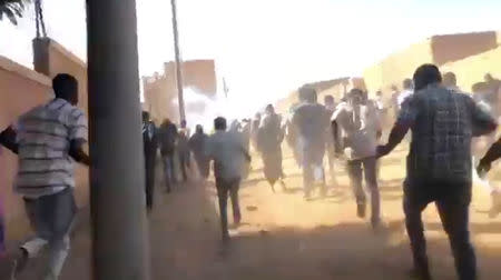 People run as tear gas canisters are thrown at them during an anti-government protest in Omdurman, Sudan January 9, 2018 in this still image taken from social media video. Haitham Seo/via REUTERS