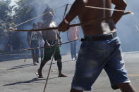 Indigenous armed with bows and arrows clash with police during a protest opposing a proposed bill the Indigenous protesters say would limit recognition of reservation land, outside Congress in Brasilia, Brazil, Tuesday, June 22, 2021. (AP Photo/Eraldo Peres)