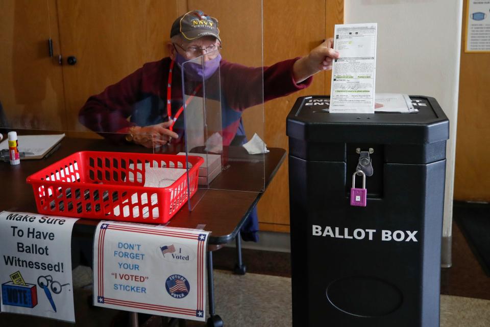 An election worker drops a voter's completed ballot into a ballot box inside City Hall on the first day of in-person early voting for the November 3rd elections in Kenosha, Wisconsin, on October 20, 2020. / Credit: KAMIL KRZACZYNSKI/AFP via Getty Images