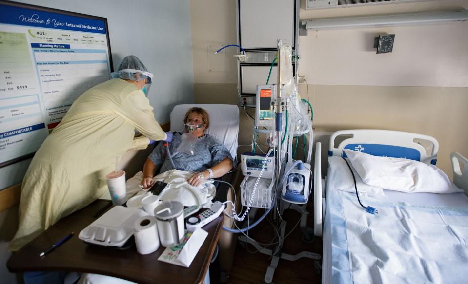 Jaclynn Moss, RN Nurse Manager of Internal Medicine at Tallahassee Memorial HealthCare, adjusts a tube connected to COVID patient, Tanya English's oxygen mask Monday, Aug. 23, 2021.