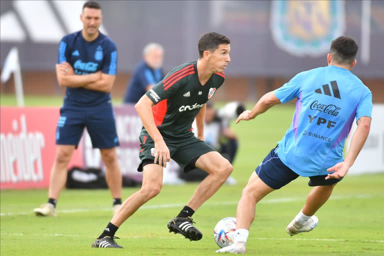 Nacho Fernández maneja la pelota ante la mirada de Scaloni; la selección le ganó a River 4 a 1