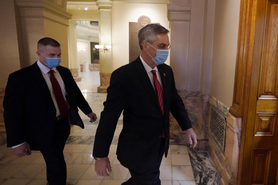 Georgia Secretary of State Brad Raffensperger, right, walks to his office in the Capitol Building Monday, Jan. 4, 2021, in Atlanta. (AP Photo/John Bazemore)