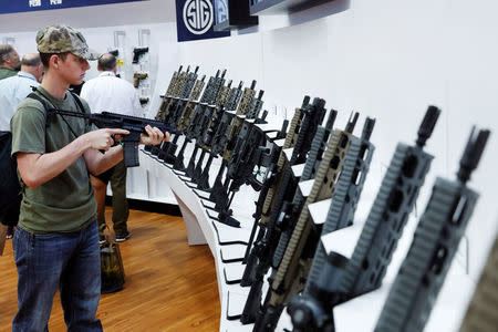 A young man tests a Sig Sauer rifle during the annual National Rifle Association (NRA) convention in Dallas, Texas, U.S., May 5, 2018. REUTERS/Lucas Jackson