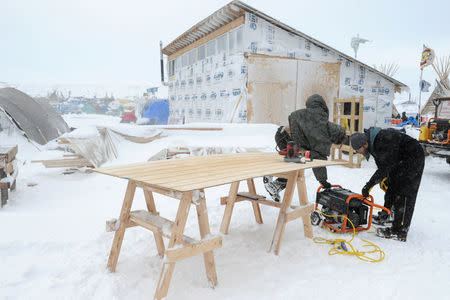 People work on a building project in the Oceti Sakowin camp in a snow storm during a protest against plans to pass the Dakota Access pipeline near the Standing Rock Indian Reservation, near Cannon Ball, North Dakota, U.S. November 29, 2016. REUTERS/Stephanie Keith