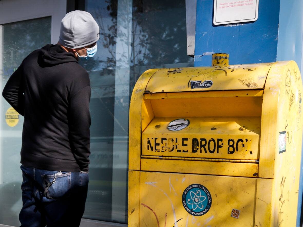 A man waits to enter the Safeworks supervised injection site in Calgary in this photo from 2021. P.E.I.'s first supervised consumption site was set to open soon, but its location and timeline are now up in the air. (Jeff McIntosh/The Canadian Press - image credit)