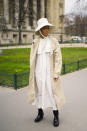 <p>A guest is spotted wearing a super chic trench coat with a matching hat and stompy boots. <em>[Photo: Getty]</em> </p>