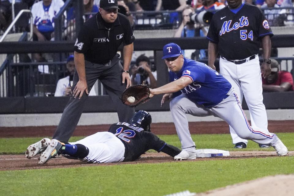 New York Mets' Francisco Lindor gets back to first base safely on a pickoff throw to Texas Rangers' Nathaniel Lowe during fourth inning of a baseball game, Friday, July 1, 2022, in New York. (AP Photo/Bebeto Matthews)