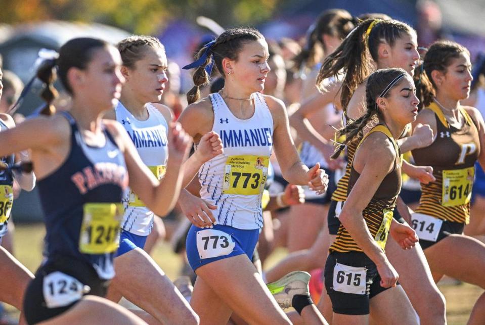 Top Immanuel runner Clara Riddle, center, runs with the pack at the start of the girls Division V state cross country championships at Woodward Park in Fresno on Saturday, Nov. 25, 2023.