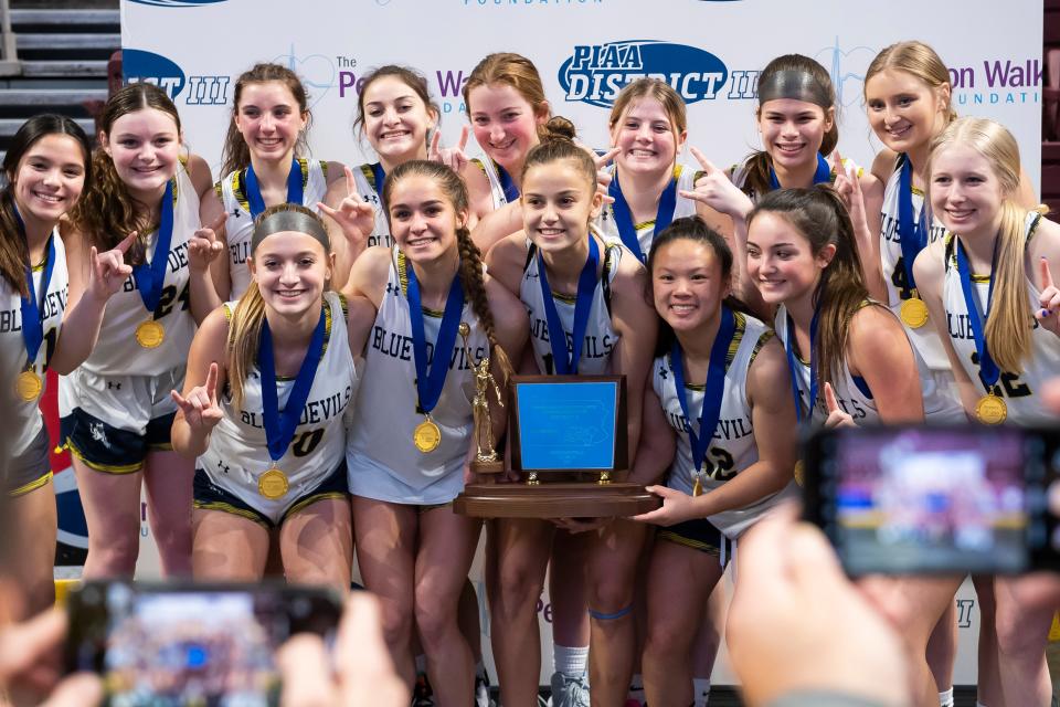 The Greencastle-Antrim Blue Devils celebrate with their trophy after winning the District 3 Class 5A girls' basketball championship at the Giant Center on March 2, 2023, in Derry Township.