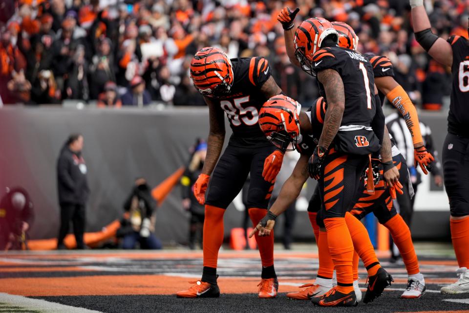 Cincinnati Bengals running back Joe Mixon (28) pulls a coin from his first band and flips it in the end zone after running in a touchdown in the first quarter of the NFL Week 18 game between the Cincinnati Bengals and the Baltimore Ravens at Paycor Stadium in downtown Cincinnati on Sunday, Jan. 8, 2023. The Bengals led 24-7 at halftime.