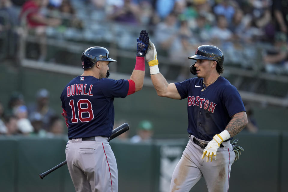 Boston Red Sox's Jarren Duran, right, celebrates with Adam Duvall after scoring against the Oakland Athletics on Justin Turner's sacrifice fly during the first inning of a baseball game Monday, July 17, 2023, in Oakland, Calif. (AP Photo/Godofredo A. Vásquez)