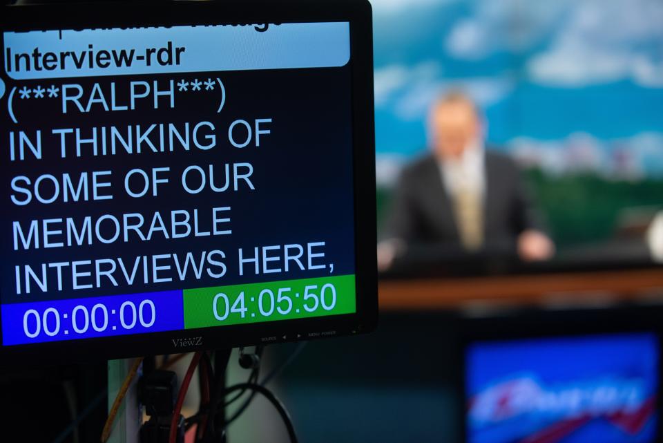 A teleprompter in the studio at WIBW-TV Channel 13 tells anchor Ralph Hipp what to say as he talks about the red couch.