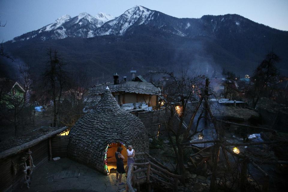 Bathhouse workers Roman Korotkov, center left, and Alexander Bogatov chat in the outdoor sauna area at the British Banya bathhouse, Saturday, Feb. 15, 2014, in Krasnaya Polyana, Russia. The eclectic outdoor bathhouse is just a few miles away from the ski slopes where athletes are competing for Olympics medals. (AP Photo/Jae C. Hong)