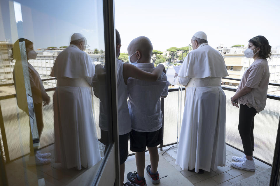 Pope Francis appears with some young oncologic patients at a balcony of the Agostino Gemelli Polyclinic in Rome, Sunday, July 11, 2021, where he was hospitalized for intestine surgery, to deliver his traditional Sunday blessing. (Vatican Media via AP)