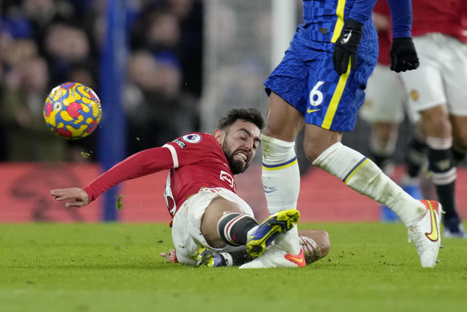 Manchester United's Bruno Fernandes, on the ground, fouls Chelsea's Thiago Silva during the English Premier League soccer match between Chelsea and Manchester United at Stamford Bridge stadium in London, Sunday, Nov. 28, 2021. (AP Photo/Kirsty Wigglesworth)