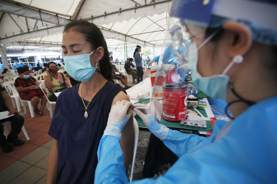 In this Tuesday, May 4, 2021, photo, a health worker administers a dose of the Sinovac COVID-19 vaccine to residents of the Klong Toey area, a neighborhood currently having a spike in coronavirus cases, in Bangkok, Thailand. Health officials rushed to vaccinate thousands of people in Bangkok's biggest slum on Wednesday as a new surge in COVID-19 cases spread through densely populated low-income areas located in the capital's central business district.(AP Photo/Anuthep Cheysakron)