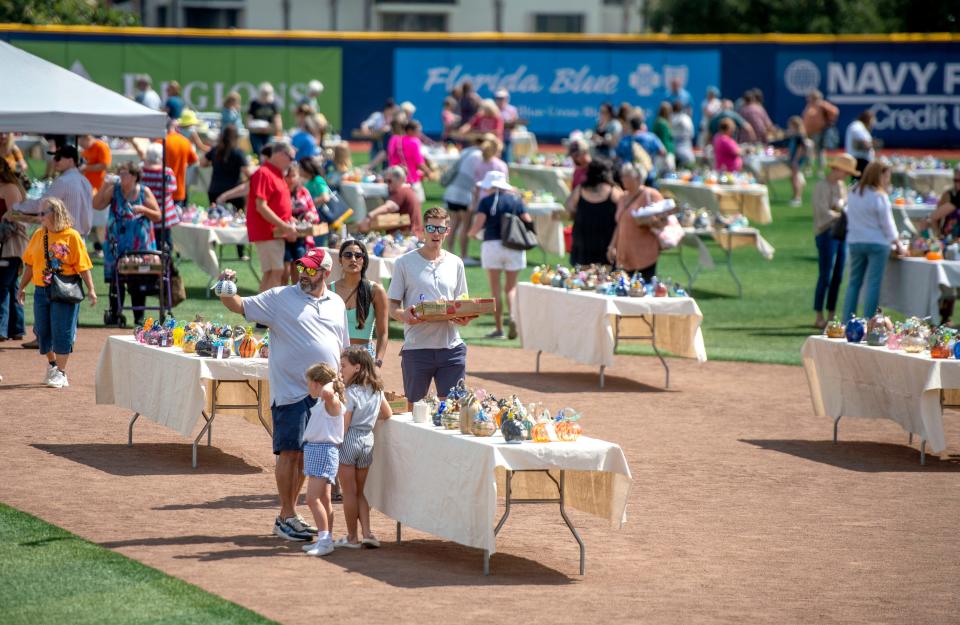 Attendees shop for their favorite pumpkin during the First City Art Center's Glass and Ceramic Pumpkin Patch at Blue Wahoo's Stadium Saturday, October 8, 2022.