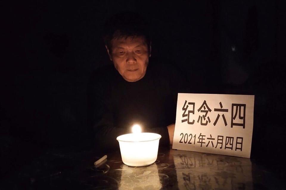 In this photo taken June 4, 2021 and released by Chen Siming, he poses for photos with a paper which reads ‘Commemorate June 4, on 2021, June 4’ near a candle light in Zhuzhou in central China’s Hunan province. The Chinese dissident is known for regularly commemorating the 4 June 1989 crackdown on pro-democracy protesters in Beijing’s Tiananmen Square (AP)