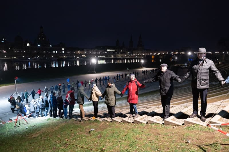Citizens form a human chain on Neumarkt in front of the Frauenkirche during an event marking the 78th anniversary of the bombing of Dresden in World War II. Sebastian Kahnert/dpa