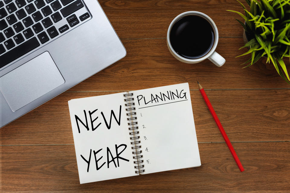 New Year Resolution Goal and Target Setting List 2020 - Business office desk with notebook written in handwriting about plan listing of new year goals and resolutions setting. Change and determination concept.