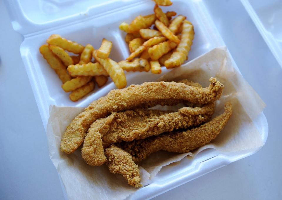 An order of cornmeal breaded catfish with fries is boxed up and ready to go inside the Lee's Phillies and More truck on Friday, Jan. 28, 2023.