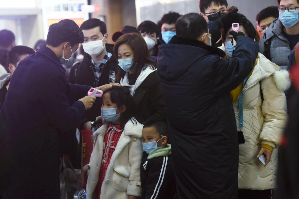 Staff members check body temperatures of the passengers arriving from the train from Wuhan to Hangzhou, at Hangzhou Railway Station ahead of the Chinese Lunar New Year in Zhejiang