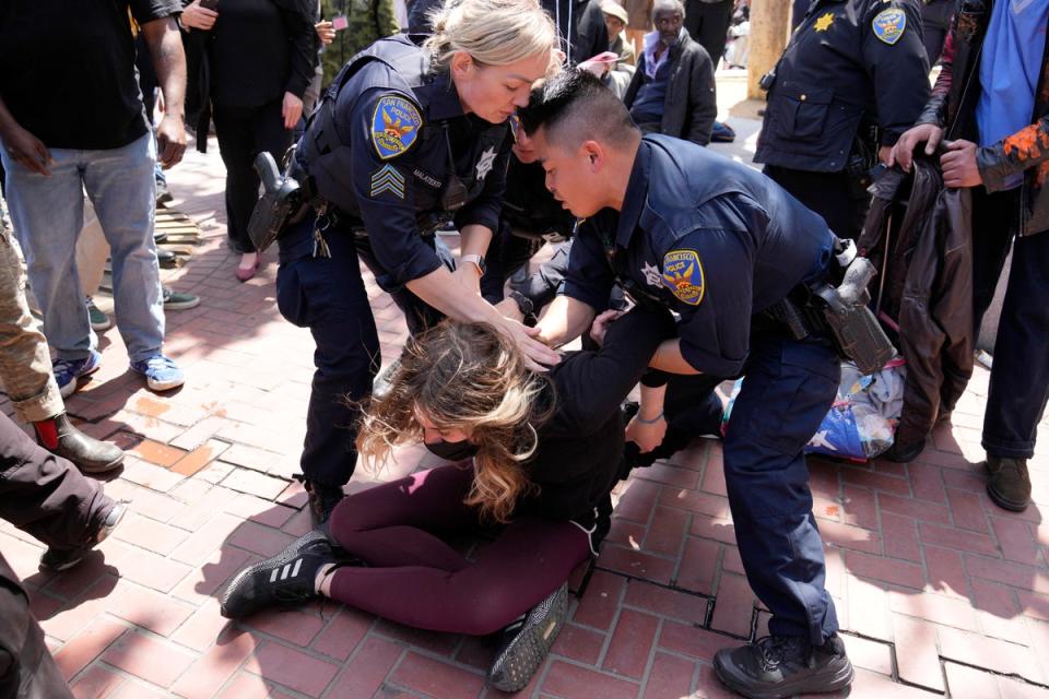 A protester who threw a brick at a color guard after a rare outdoor meeting of the Board of Supervisors is restrained by police at UN Plaza in San Francisco, Tuesday, May 23, 2023. (AP)
