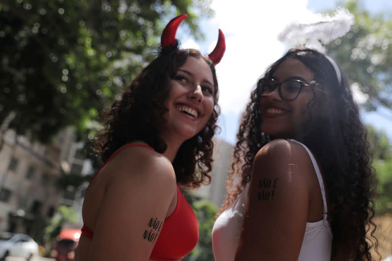 Revellers are seen with temporary tattoos that read “No means No” during a carnival block party in Sao Paulo