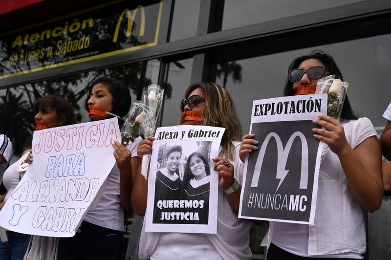 People protest outside a closed McDonald's restaurant, after the the deaths of two teenaged employees, in Lima