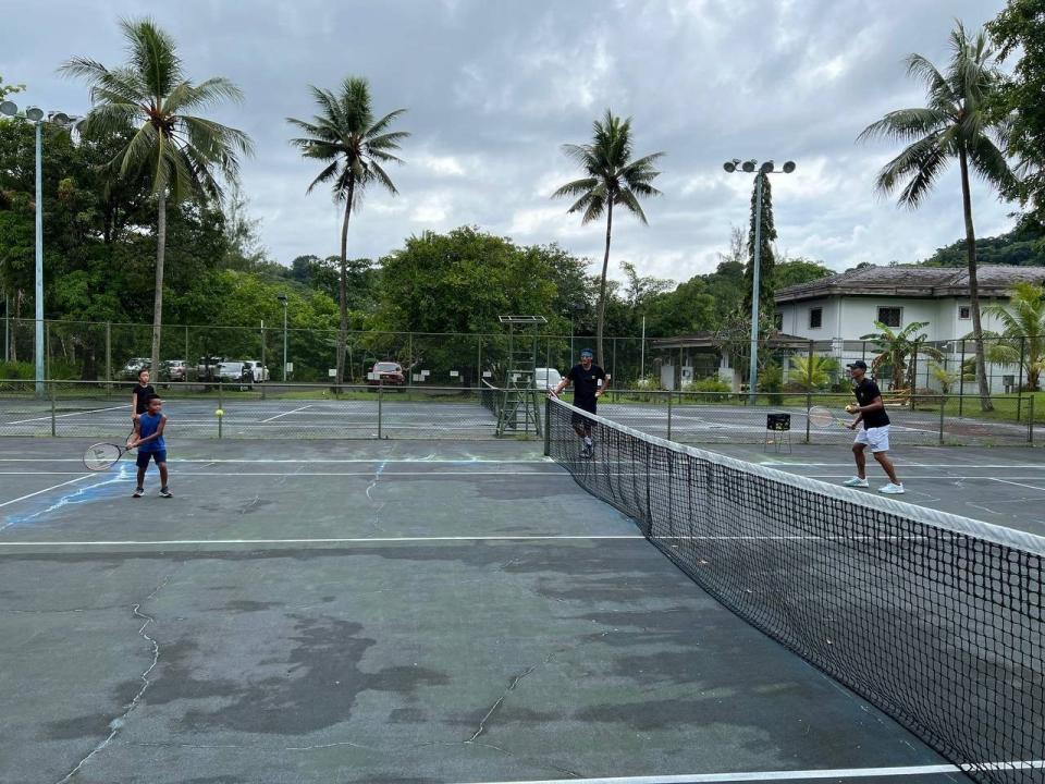 盧彥勳（右）在帛琉當地和小朋友打網球。外交部提供